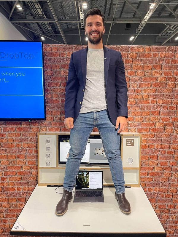 Man standing on a DropTop desk to show how strong it is.