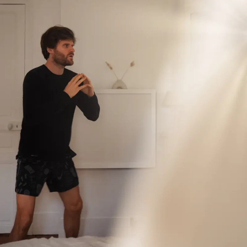 valhery doing yoga in a bright bedroom infront of a droptop