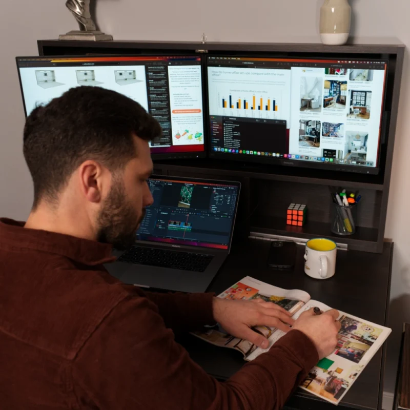 Stefan husanu taking notes while working on black brown sorano droptop with a MacBook Pro on his desk
