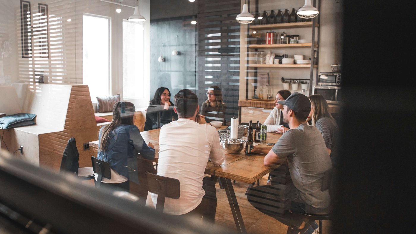 A group discussion happening round a table in an office rest area.