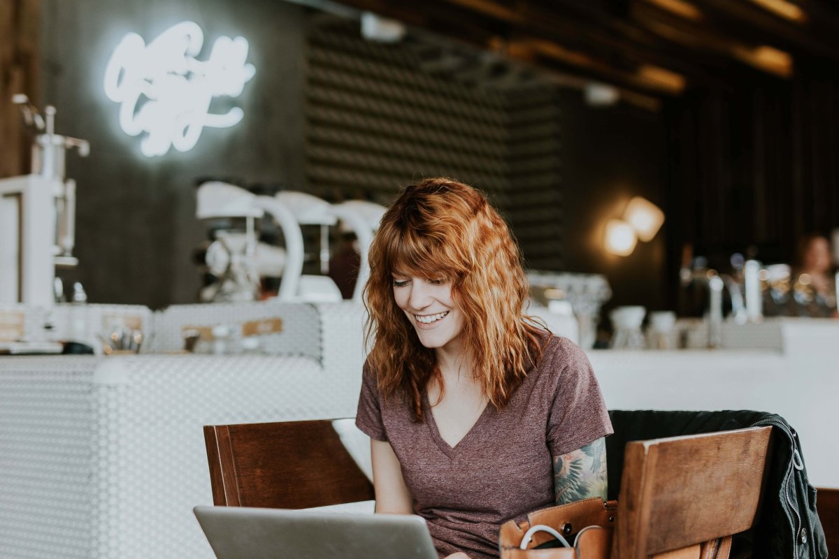 A lady working at a table on her laptop.