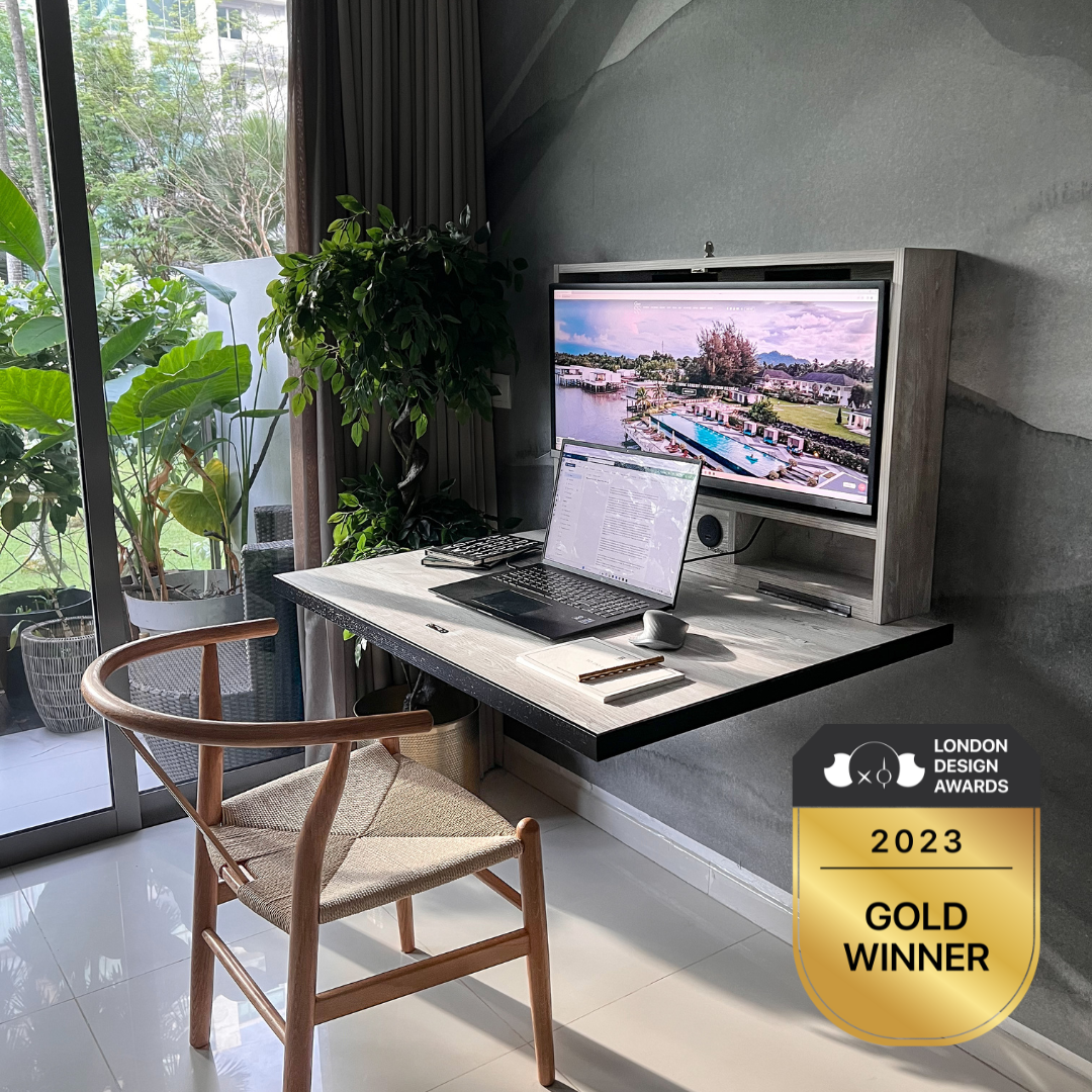 Modern interior with greenery and a foldable desk with a dell laptop and large monitor with the london design awards 2023 gold winner badge